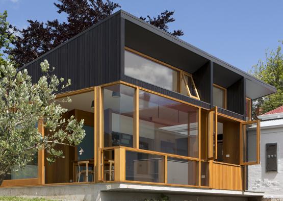 a building with a glass wall and a tree