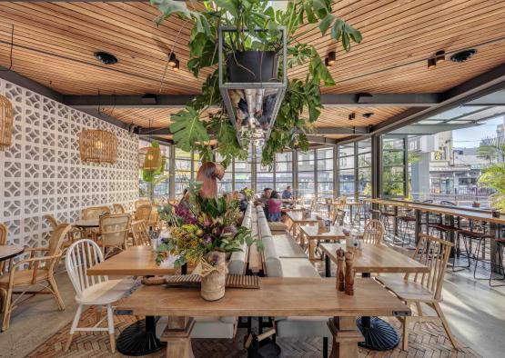 a room with tables and chairs and plants