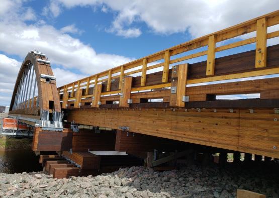 a wooden bridge with a metal railing