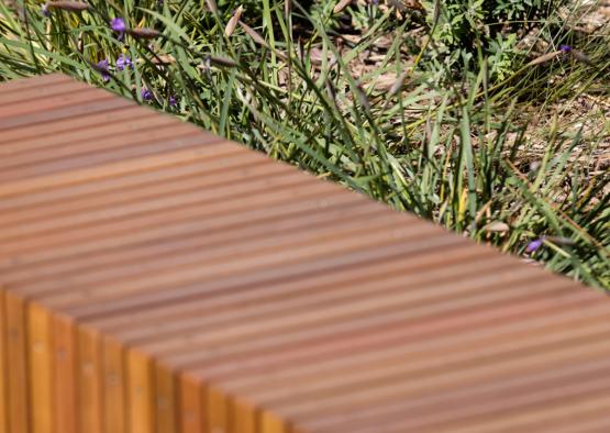 a wooden bench next to grass