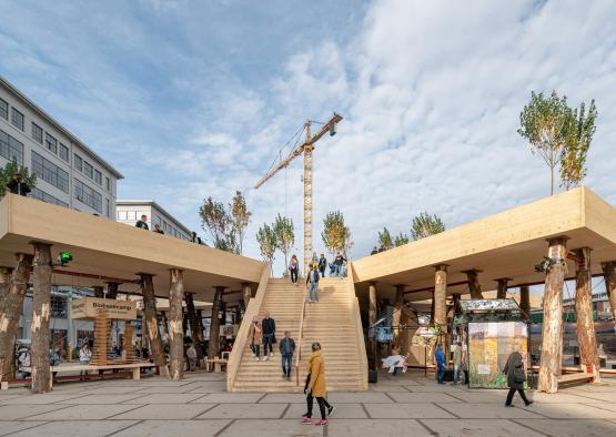 a group of people walking up stairs in a courtyard with a crane