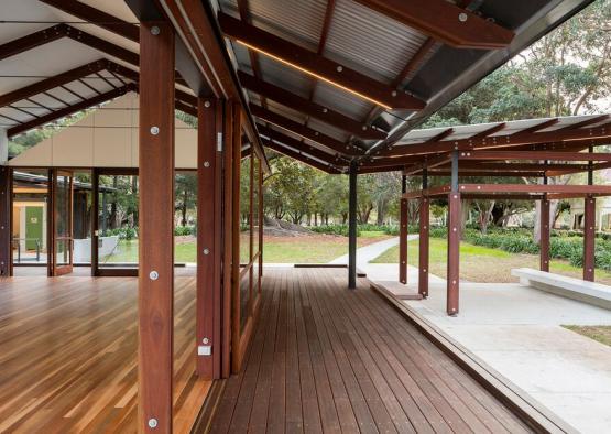 a wooden deck with a patio and trees in the background