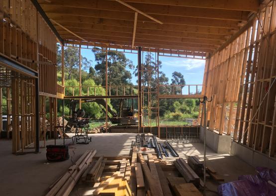 a building under construction with wood beams and a large window