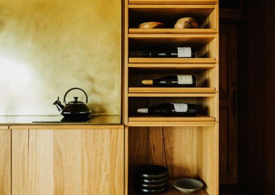 a shelf with wine bottles and plates on it