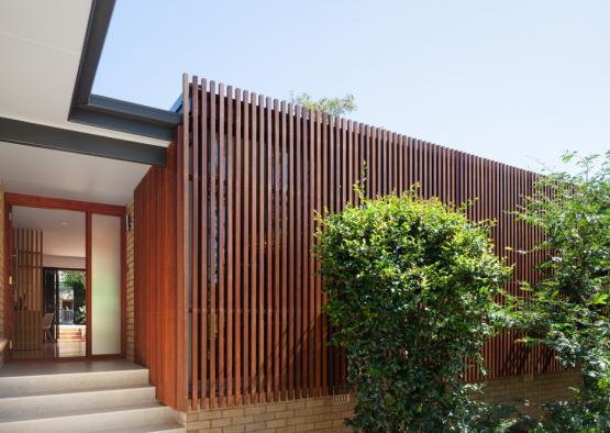 a house with a wood wall and a tree