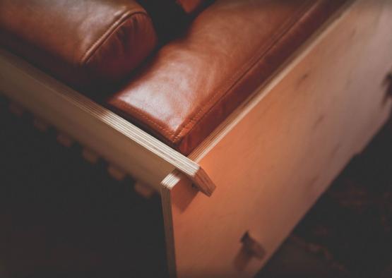 a brown leather couch with a wooden box