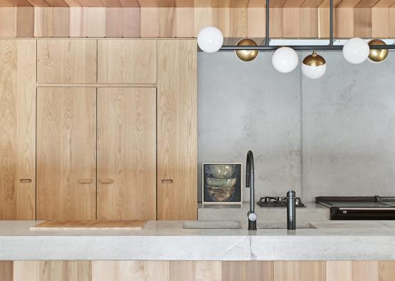 a kitchen with wood cabinets and light fixtures