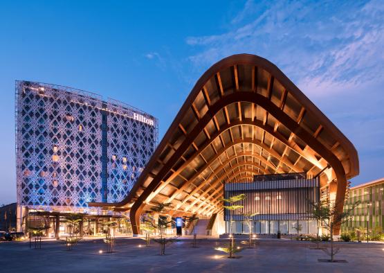 a building with a curved roof and a building with a blue sky