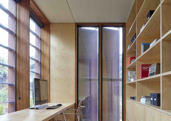 a desk with a computer in front of a large window