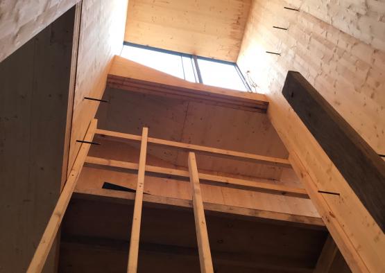 a wood structure with a window and a ladder