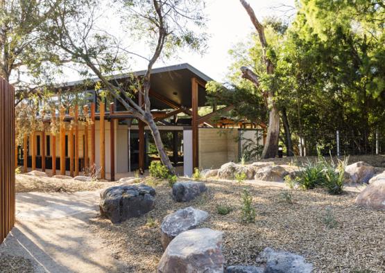 a building with a roof and rocks in front of it