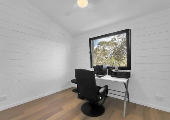 a desk and chair in a room with a window