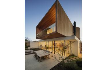 a house with a glass wall and a patio