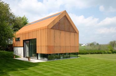 a building with a glass roof and a green lawn